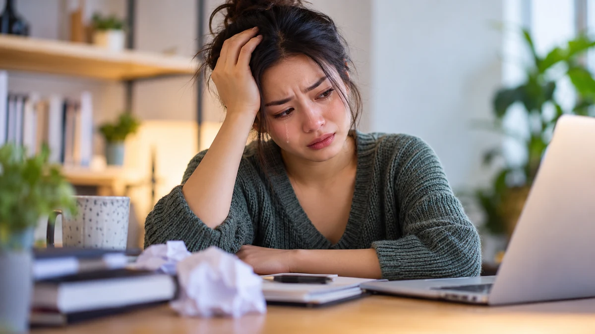 A woman crying from emotional overwhelm, illustrating why people get frustrated easily and cry.